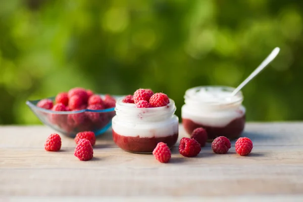 Jogurt s čerstvou malinovou na dřevěné pozadí. zdravé ráno snídaně. — Stock fotografie