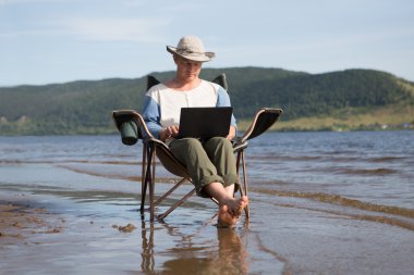 kullanan adam tatil açık havada üstünde laptop. serbest meslek. Ofis kaçtı.