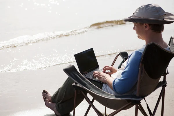 El hombre que usa el portátil en las vacaciones al aire libre. freelancer. Escapado de su cargo . — Foto de Stock
