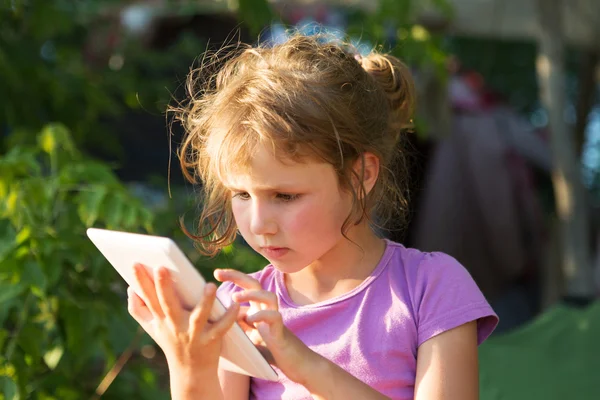 Dziecko trzymać tablet, telefon do gry i edukacji. Mała dziewczynka za pomocą tabletu na zewnątrz. — Zdjęcie stockowe