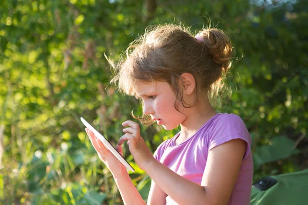 Dziecko trzymać tablet, telefon do gry i edukacji. Mała dziewczynka za pomocą tabletu na zewnątrz. — Zdjęcie stockowe