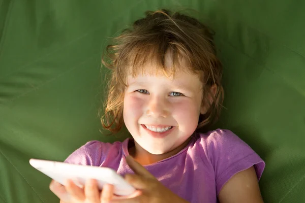 Dziecko trzymać tablet, telefon do gry i edukacji. Mała dziewczynka za pomocą tabletu na zewnątrz. — Zdjęcie stockowe
