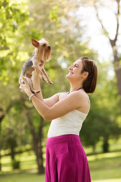 Retrato de la joven mujer hermosa sosteniendo un perrito en las manos — Foto de Stock