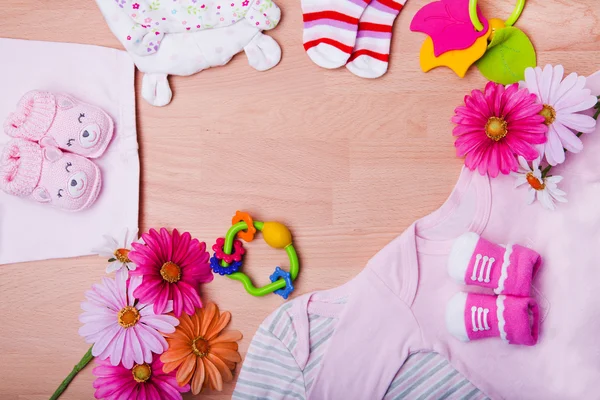 Nyfödd babykläder med leksaker på trä bakgrund — Stockfoto