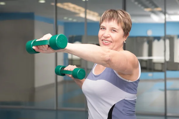 Porträt einer hübschen Seniorin, die mit Hanteln trainiert — Stockfoto