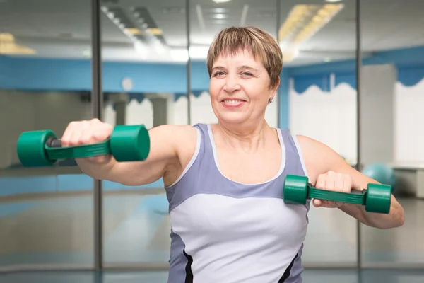 Porträt einer hübschen Seniorin, die mit Hanteln trainiert — Stockfoto