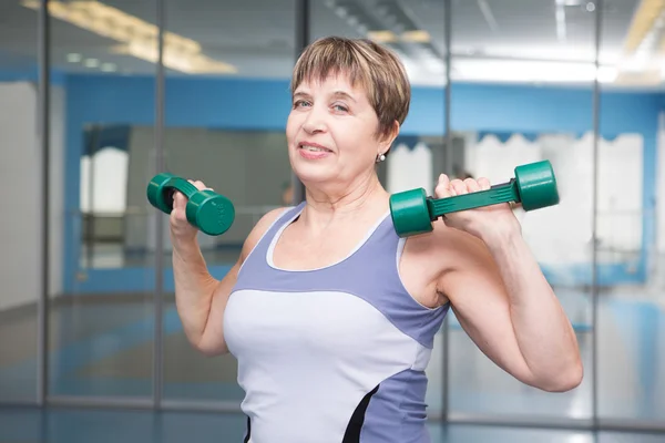 Porträt einer hübschen Seniorin, die mit Hanteln trainiert — Stockfoto