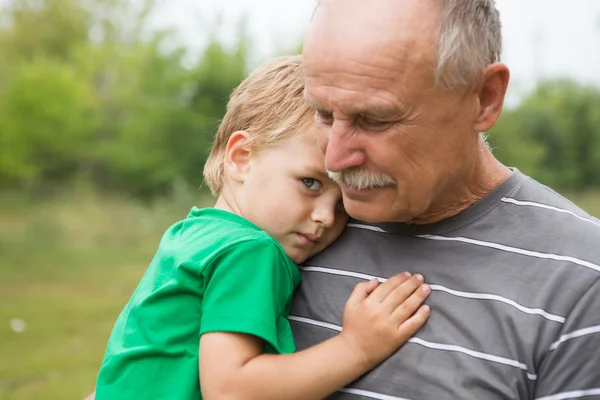 Sad little child, boy, hugging his grandfather at outdoors. Family concept — Stock Photo, Image