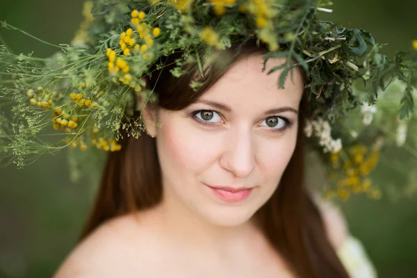 Νεαρή όμορφη γυναίκα στο στεφάνι με λουλούδια σε εξωτερικούς χώρους στη φύση — Φωτογραφία Αρχείου
