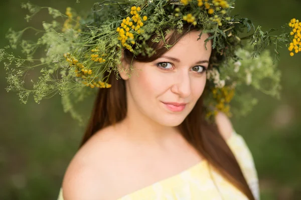 Νεαρή όμορφη γυναίκα στο στεφάνι με λουλούδια σε εξωτερικούς χώρους στη φύση — Φωτογραφία Αρχείου