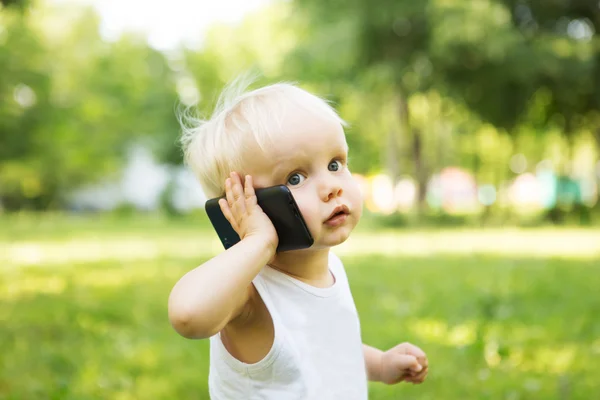 El niño habla por teléfono en el parque — Foto de Stock