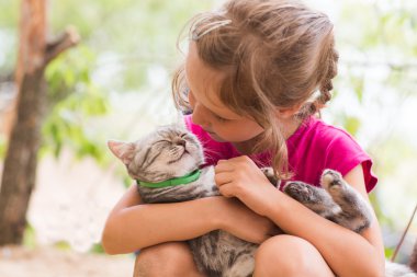 Açık havada kedi ile mutlu çocuk.