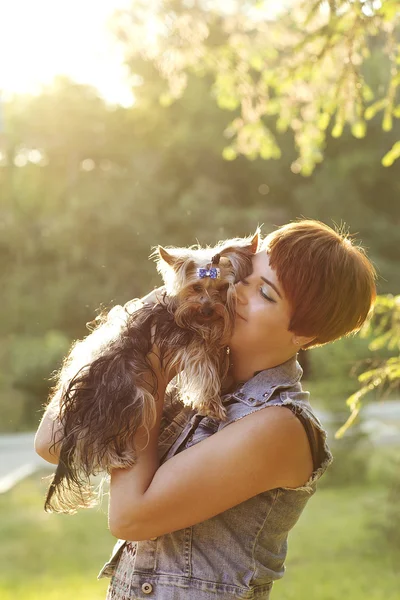 Hermosa joven feliz mujer sosteniendo perro pequeño en el día de verano paseos en el parque — Foto de Stock