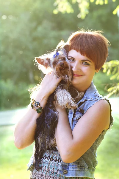 Belle jeune femme heureuse tenant un petit chien en été journée promenades dans le parc — Photo