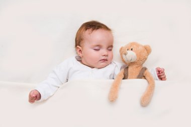 Bebek yatakta yatıyordu. Bebek oyuncak ayı, yeni ailesinden ve aşk kavramı ile uyku.