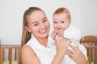 Mutlu bir aile. Anne yatak odasında bebeğiyle oynuyor..