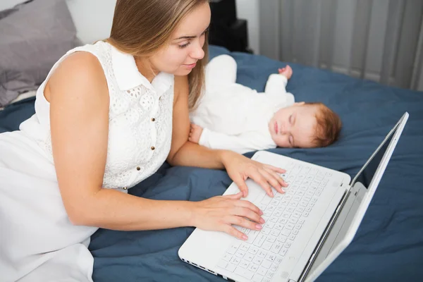 Mãe feliz com sua menina usando laptop em casa — Fotografia de Stock