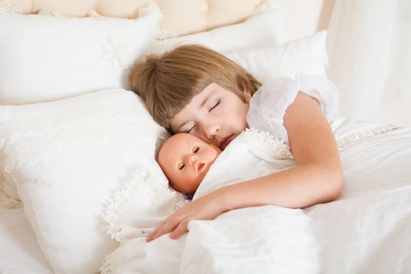 Onu oyuncak ile yatakta uyuyan sevimli küçük çocuk kız. — Stok fotoğraf