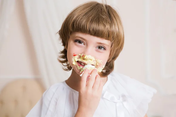 Милая маленькая девочка ест торт . — стоковое фото