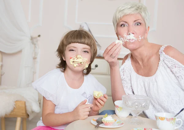Мать и маленькая дочь едят разноцветные торты — стоковое фото