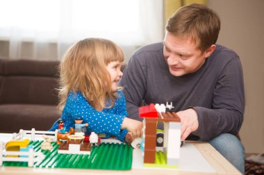 Babasıyla bulmaca blokları yapan sevimli küçük kız..