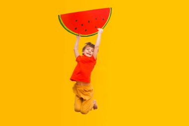 Küçük çocuk elinde bir karpuz meyvesi örneği tutuyor.. 