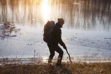 Gölün kenarında yürüyen adam.