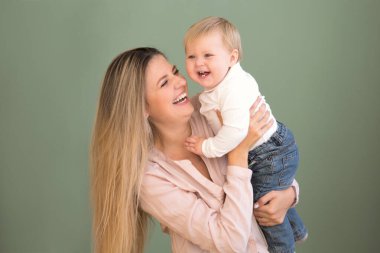 Mutlu genç anne ve küçük kızı evde.