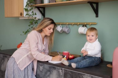 Mutlu anne ve kız mutfakta oynuyorlar.