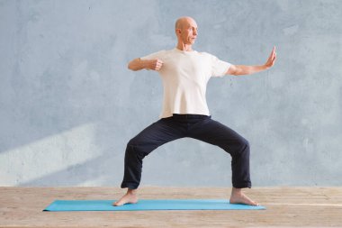 Adam spor salonunda Tai Chi Chuan yapıyor. Çin yönetimi yeteneği Qi 'nin enerjisi. WU-SHU. Yoga yapan adam..