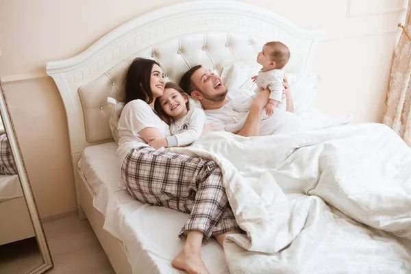 Jovens Pais Felizes Com Filhas Brincando Juntos Enquanto Deitado Cama — Fotografia de Stock