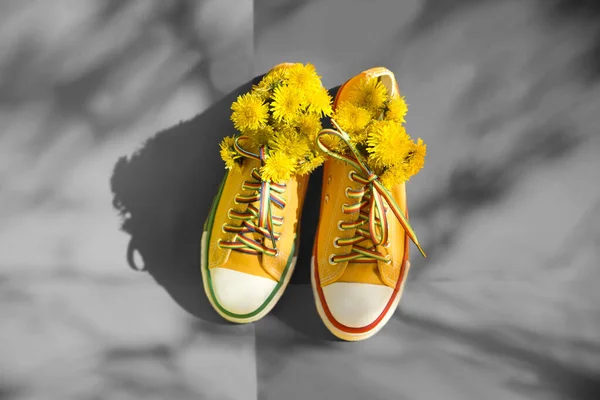 Yellow Shoes Flowers Dandelions Grey Background Shadows Trees Copy Space — Stock Photo, Image