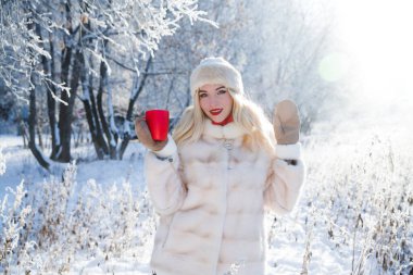 Güzel kız kış yürüyüşünde sıcak çay ya da çikolata içer.