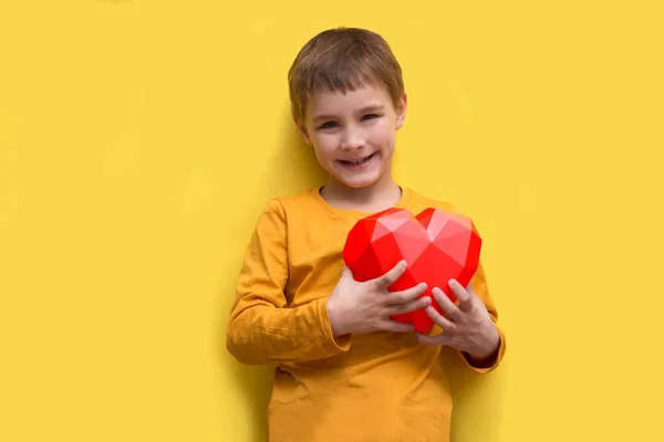 Glad Pojke Hålla Ett Hjärta Gul Bakgrund Alla Hjärtans Dag — Stockfoto