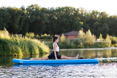 Yoga yapan genç ve çekici bir kadın yemek masasında egzersiz yapıyor. Açık hava yaz aktivitesi. N 'aber yoga. Sosyal Mesafe. kopyalama alanı. Akıl Sağlığı
