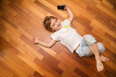 Çocuk yerde oyuncak bir arabayla oynuyor.