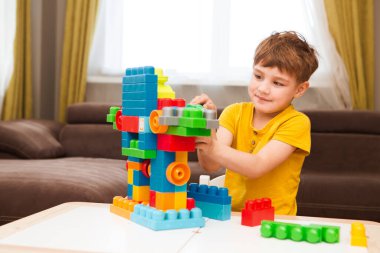 Küçük çocuk bir sürü renkli plastik bloklarla oynuyor.. 