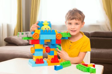 Küçük çocuk bir sürü renkli plastik bloklarla oynuyor.. 