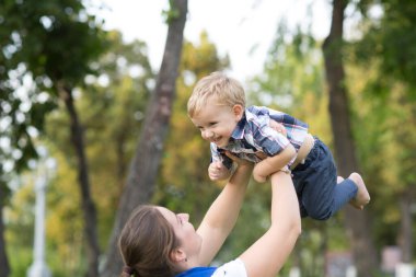 Anne ve oğlu parkta birlikte oynuyorlar. Mutlu aile kavramı