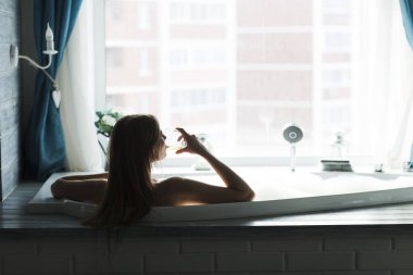 a young woman resting bath of foam and drinks wine. lifestyle. Day spa. 