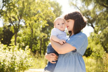 Mutlu bir aile babası, anne ve bebek yazın doğada gülüp oynuyorlar. Boşluğu kopyala