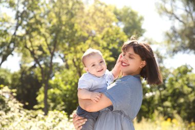 Mutlu bir aile babası, anne ve bebek yazın doğada gülüp oynuyorlar. Boşluğu kopyala