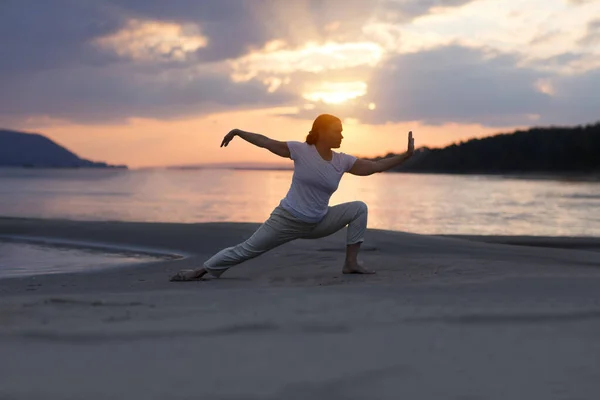 日落时分 妇女在海滩上戏弄太极拳 中国管理技巧齐的精力 个人户外活动 社会疏离 图库图片