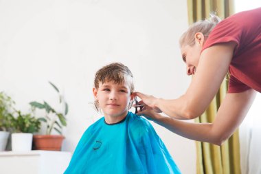 Annem saç stili yapıyor, evde çocuk için saç kesiyor. Sosyal Mesafe. kopyalama alanı. Okul için hazırlık. Makasla kesen kuaför.