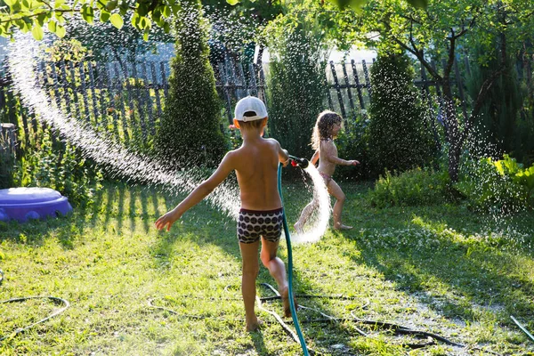 Glückliche Kinder Bruder Und Schwester Spielen Mit Gartenschlauch Und Haben — Stockfoto
