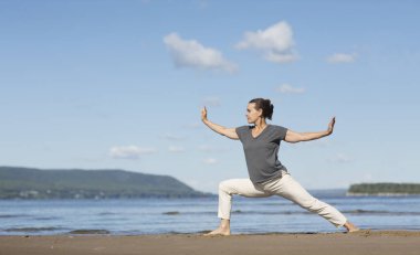 Plajda tai chi chuan yapan bir kadın. Çin yönetimi yeteneği Qi 'nin enerjisi. tek başına açık hava aktiviteleri. Sosyal Mesafe 