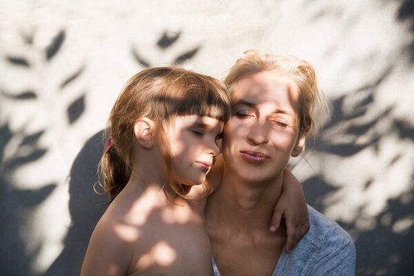 child daughter hugging her mom. Mom's day concept