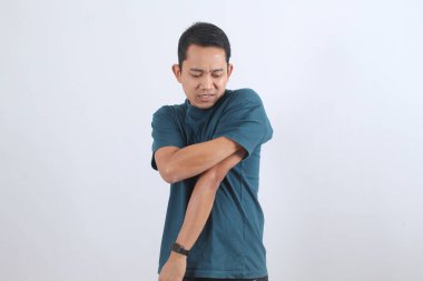 Üzgün adam kolunu tutuyor. Şiddetli kas ağrısı ya da yaralanma yüzünden buruşuyor. Eklem sorunları, iltihap veya sağlık sorunları kavramı.