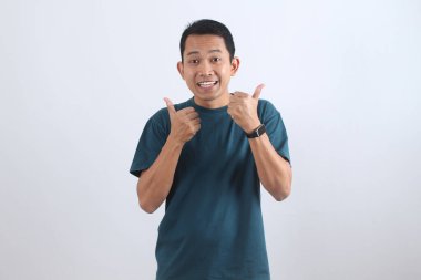 Gülümseyen ve işaret veren neşeli bir adamın portresi. Memnuniyet kavramı, olumlu geri bildirim, anlaşma ve tavsiye.