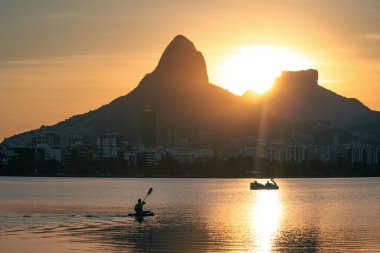 Kayaker at Sunset in Lagoa Rodrigo de Freitas with Morro Dois Irmaos and Pedra da Gavea - Rio de Janeiro, Brazil